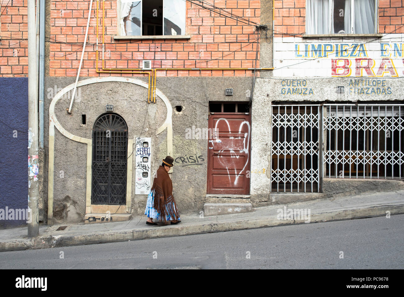 Indigenous Cholita wearing typical Bolivian clothing: bowler hat, la manta (thick shawl), la pollera (layered skirt) and flat shoes. La Paz, Bolivia Stock Photo