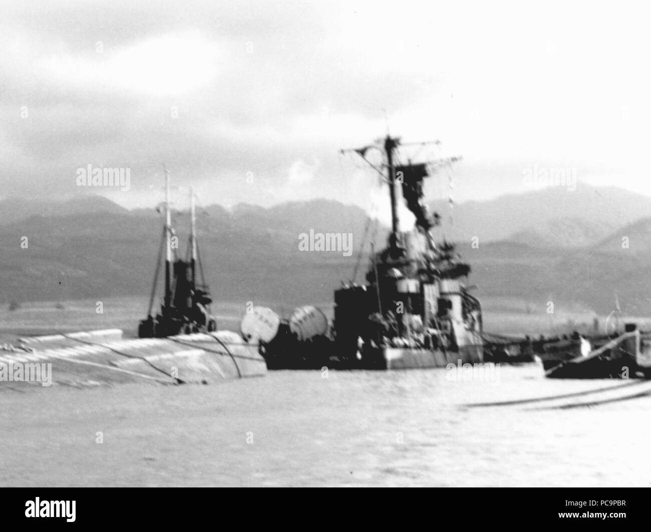 Aft view of the listing USS Raleigh (CL-7) at Pearl Harbor on 7 December 1941 (NH 97401). Stock Photo
