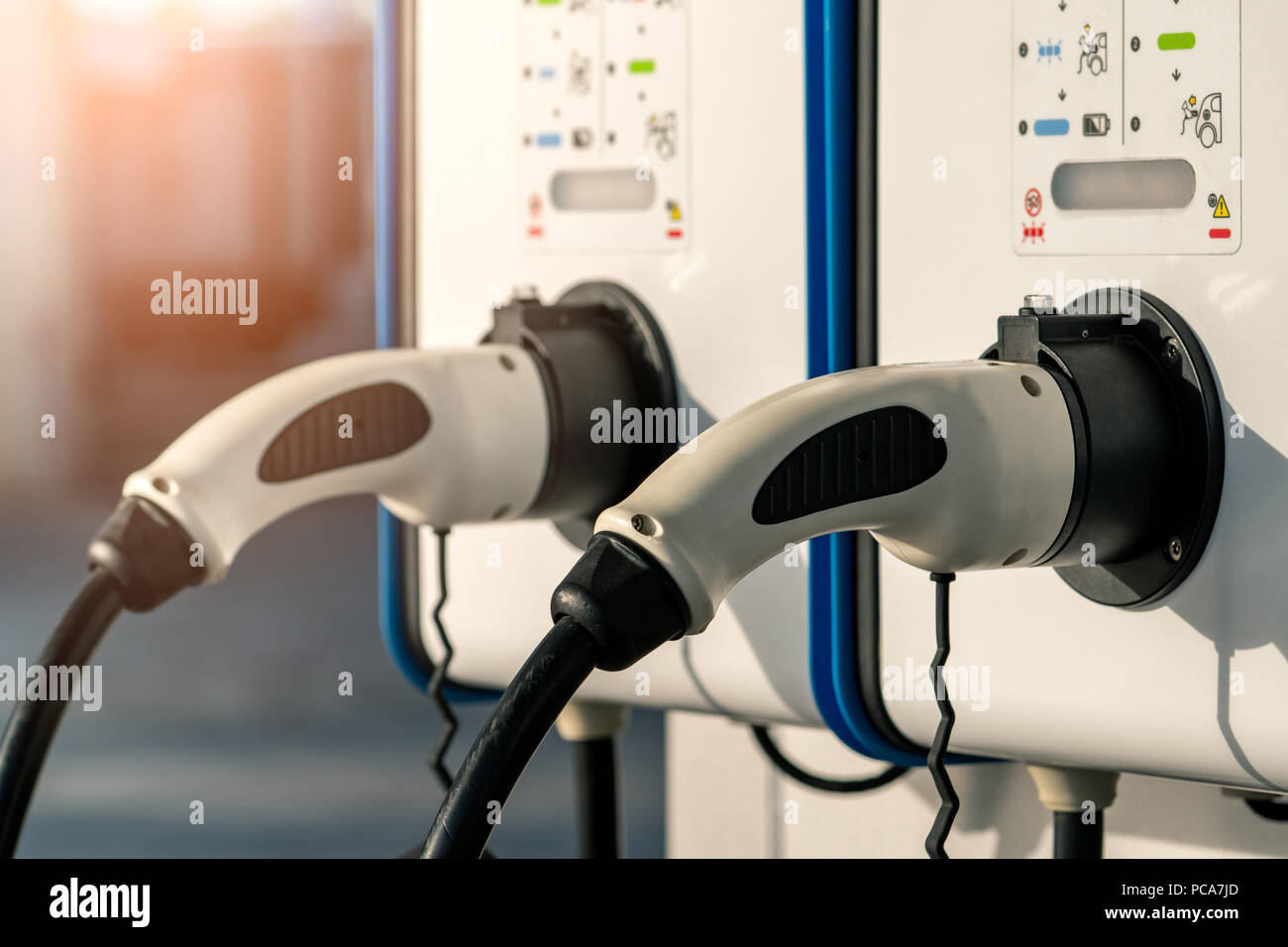 Electric car charging station. Plug for vehicle with electric motor. Coin-operated charging station. Clean energy power. Commercial charging station.  Stock Photo