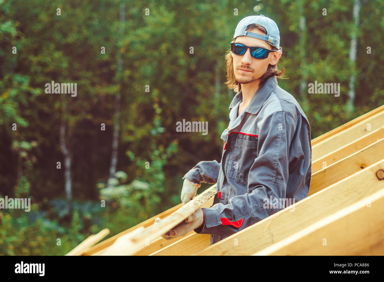 worker roofer builder working on roof structure on construction site