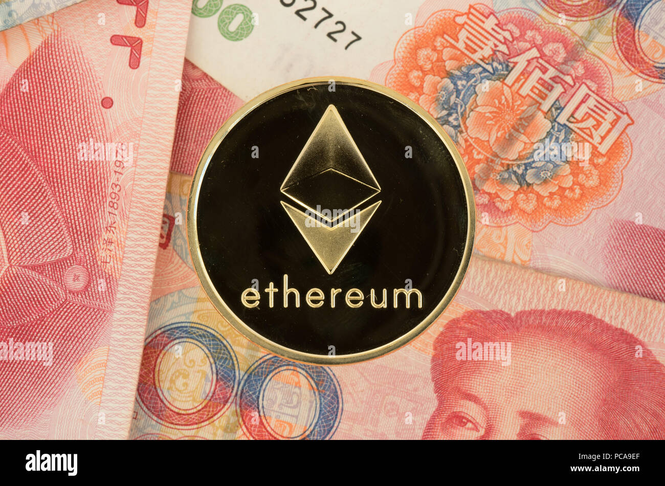 Real Ethereum coin on chinese yuan bills - crypto currency in china concept Stock Photo