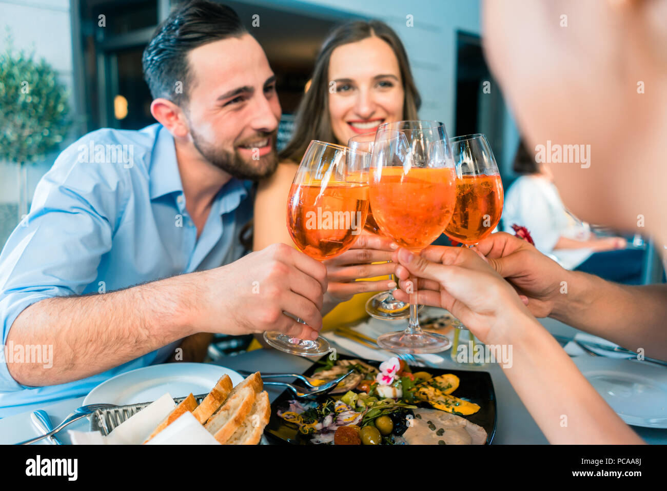 Handsome young man sitting next to his girlfriend while toasting Stock Photo