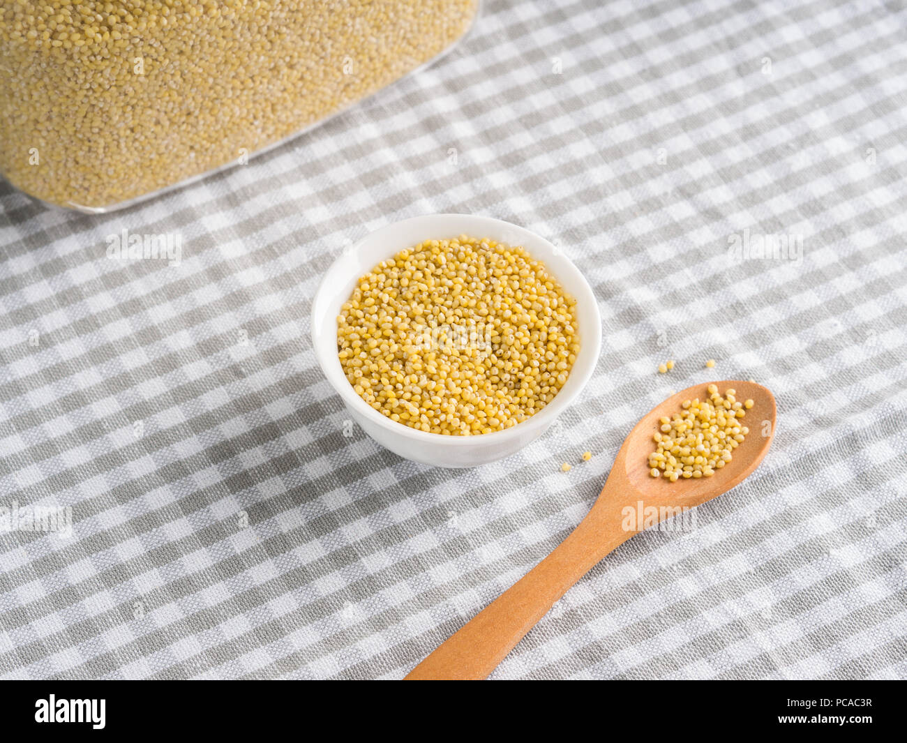 Gluten free grain millet in bowl on kitchen table. Celiac diet Stock