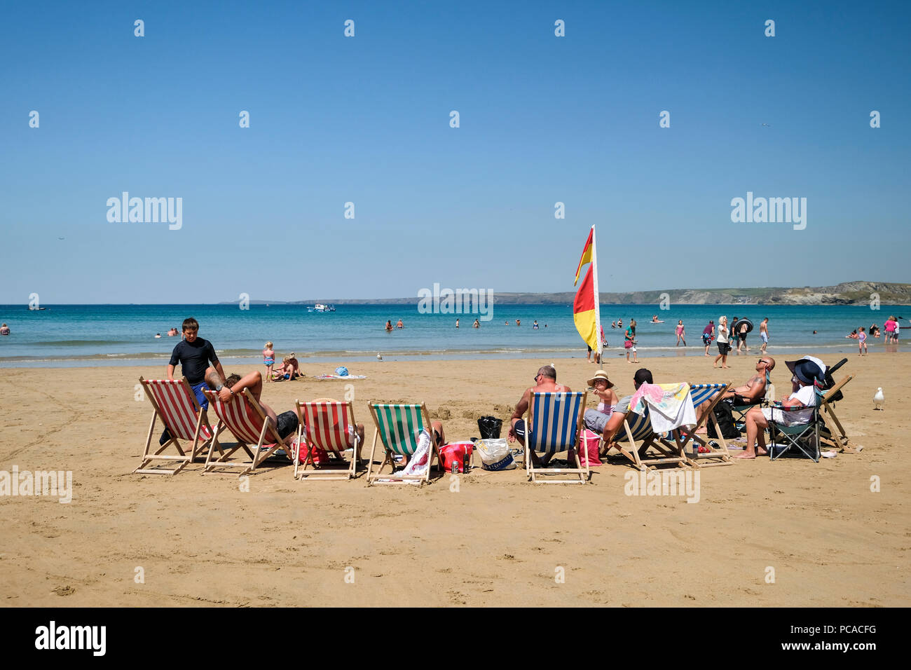 Family group sitting in deckchairs on Towan Beach at Newquay in Cornwall. Stock Photo