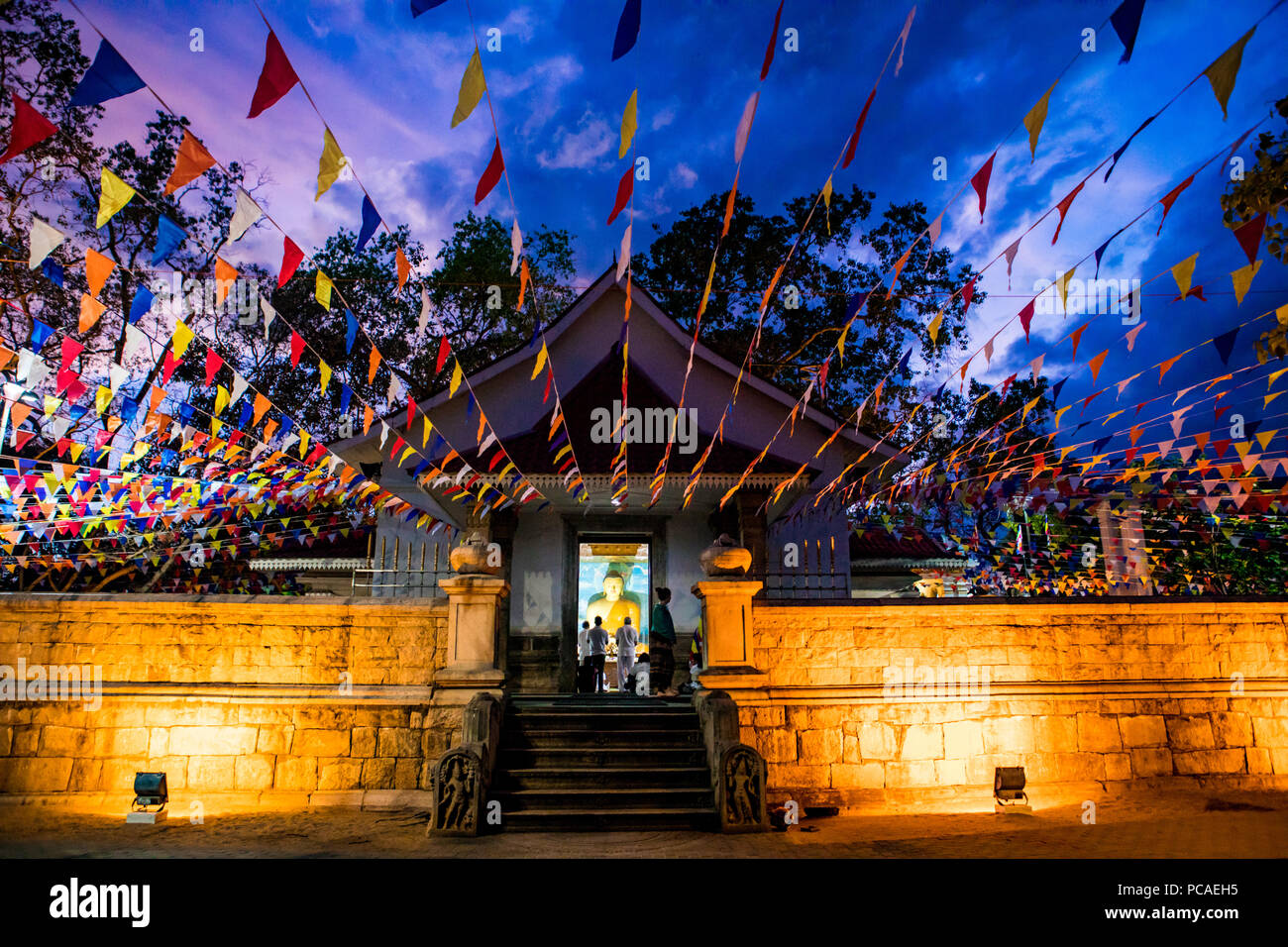 Making a prayer offering with lotus flowers at a Buddhist temple in Sri