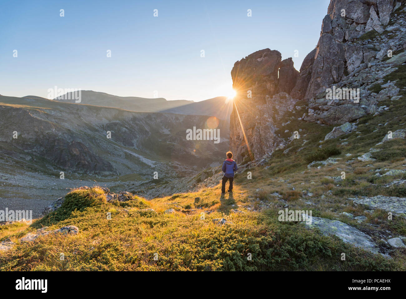The last rays of sun disappear behind a rock face after a day of trekking in the Rila Mountains, Bulgaria, Europe Stock Photo