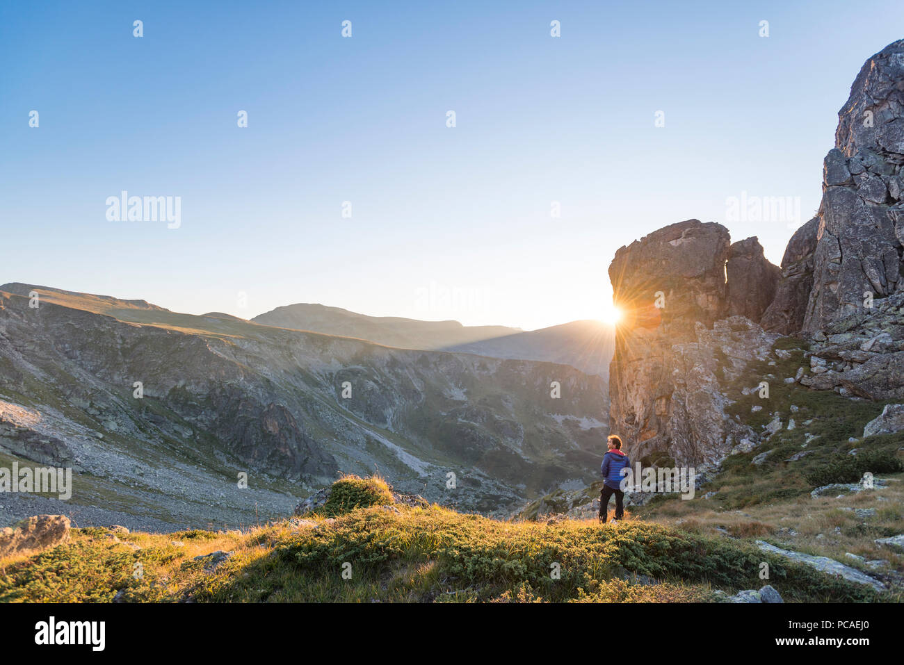 The last rays of sun disappear behind a rock face after a day of trekking in the Rila Mountains, Bulgaria, Europe Stock Photo