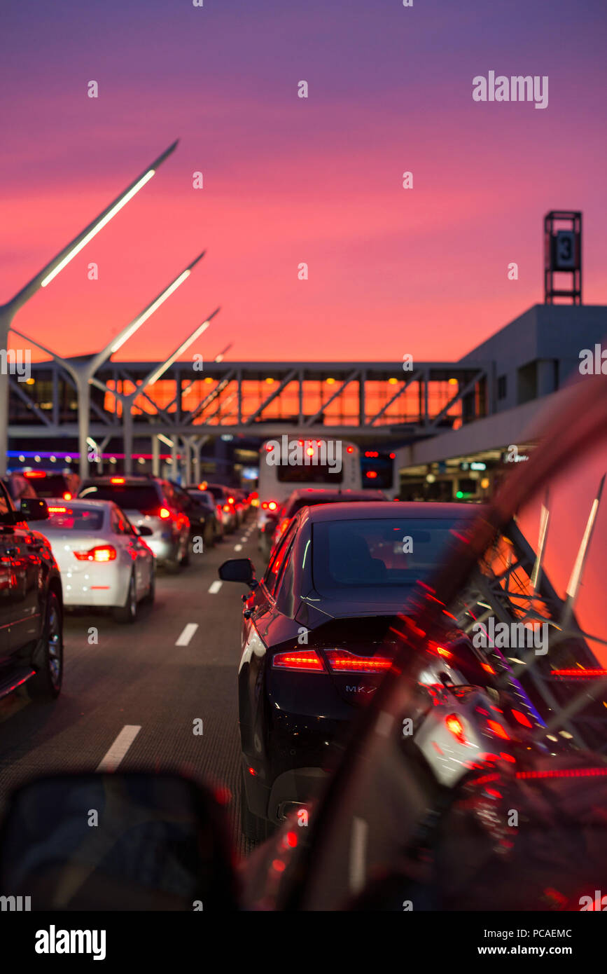 Traffic going into Los Angeles airport under a vibrant orange and pink sunset, California, United States of America, North America Stock Photo