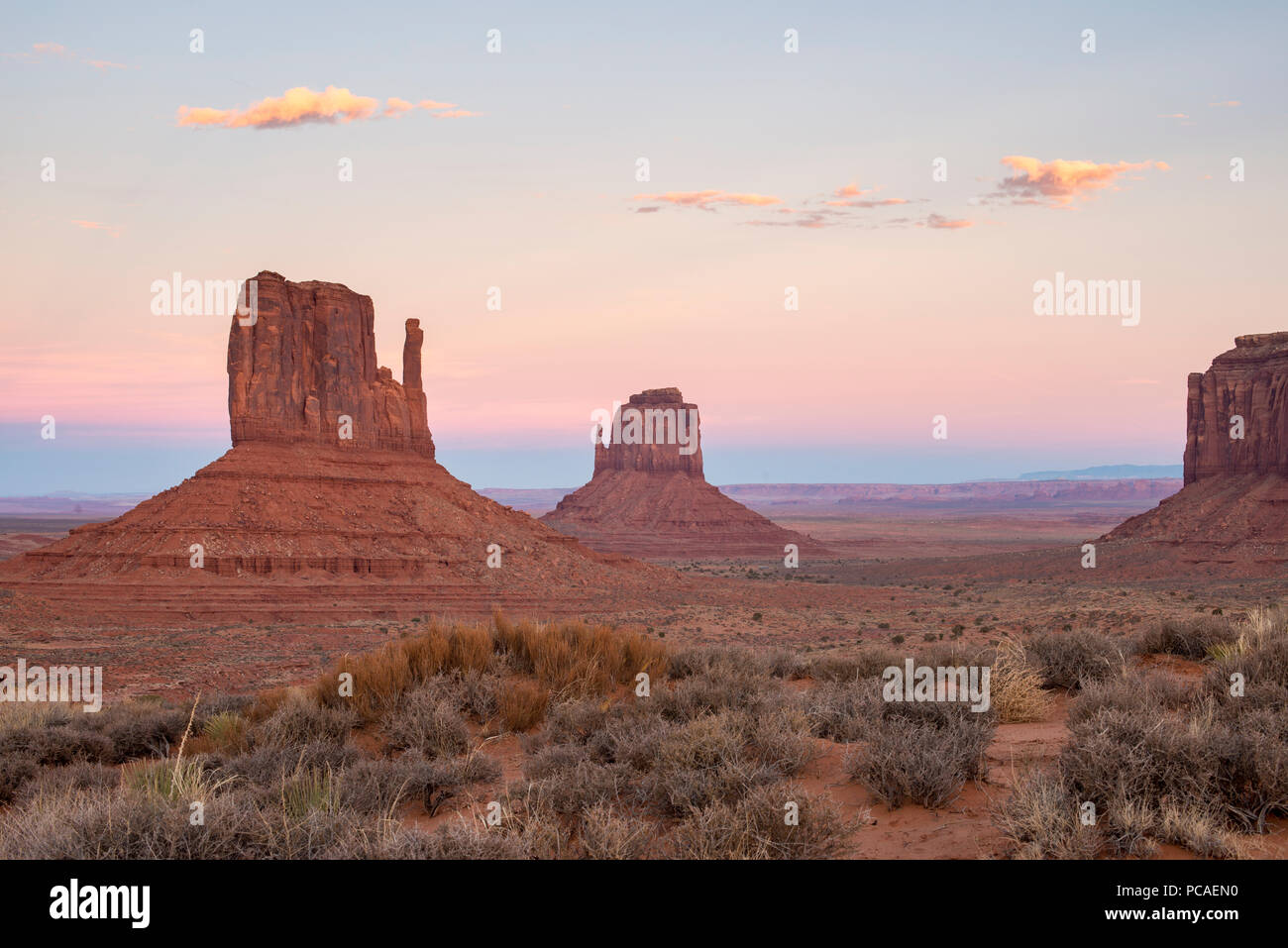 The giant sandstone buttes glowing pink at sunset in Monument Valley Navajo Tribal Park, Arizona, United States of America, North America Stock Photo