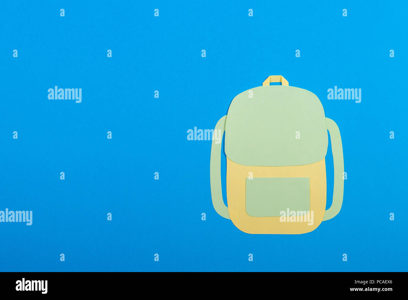 Paper cut backpack on blue background Stock Photo