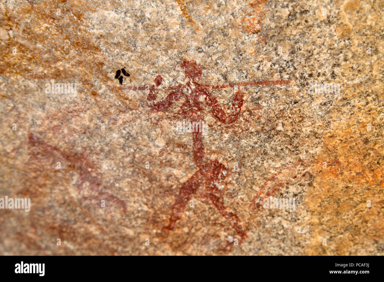Ancient rock art of painting depicting a human carrying a spear, at Matobo National Park, Zimbabwe, Africa Stock Photo