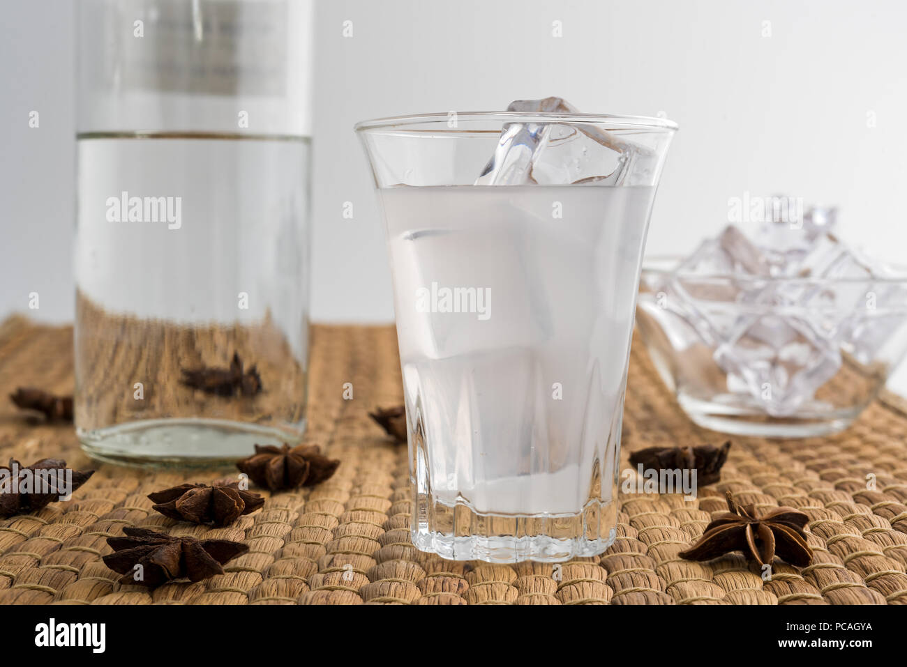 Glass and bottle of traditional drink Ouzo or Raki with anise star