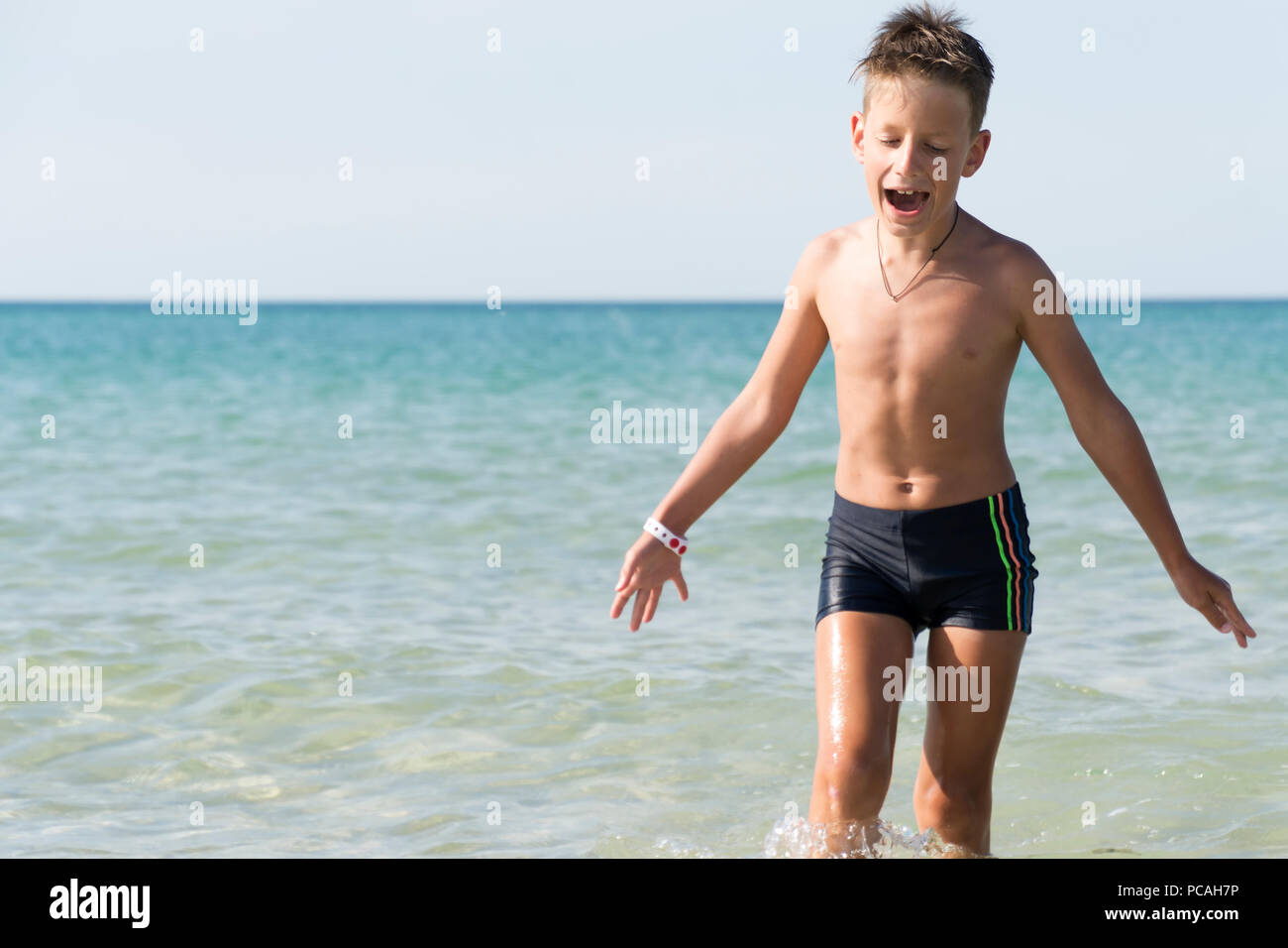 Cheerful boy sing a song on seashore background. childish spontaneity Stock Photo