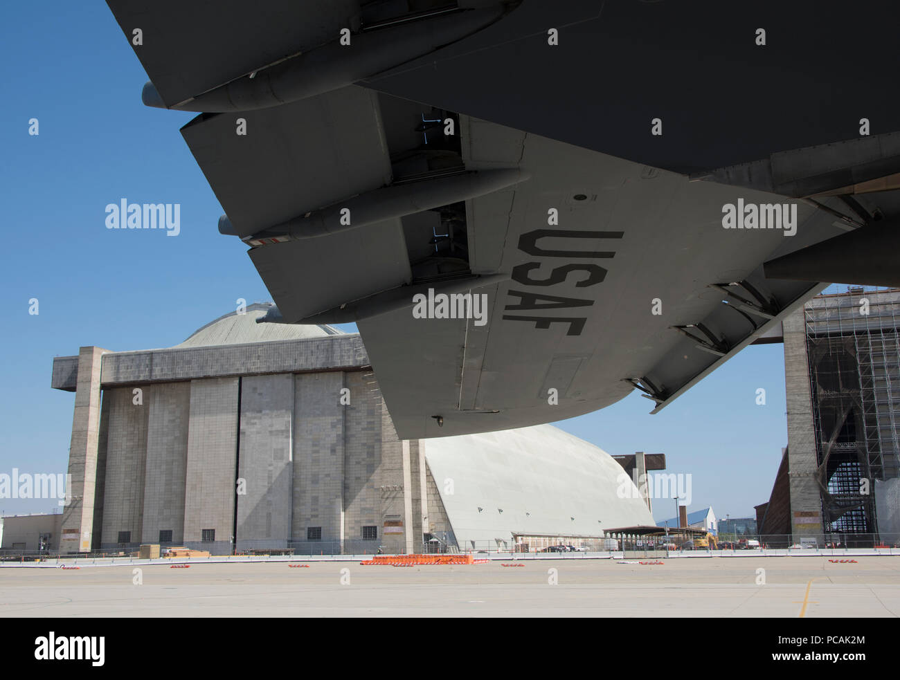 A U.S. Air Force C-5M Super Galaxy from Travis Air Force Base, Calif., is parked on the ramp in front of the huge hangers once used to house the Goodyear Blimp program, July 26, 2018, Moffett Federal Airfield, Calif. The C-5 is one of the largest aircraft in the world and the largest airlifter in the Air Force inventory. (U.S. Air Force Photo by Heide Couch) Stock Photo