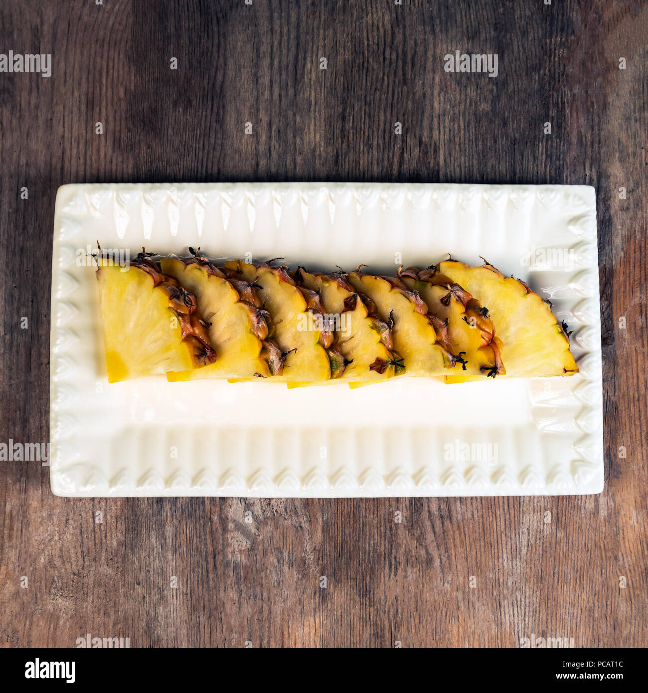 Pineapple fruit cut in wedges on plate wooden background healthy snack