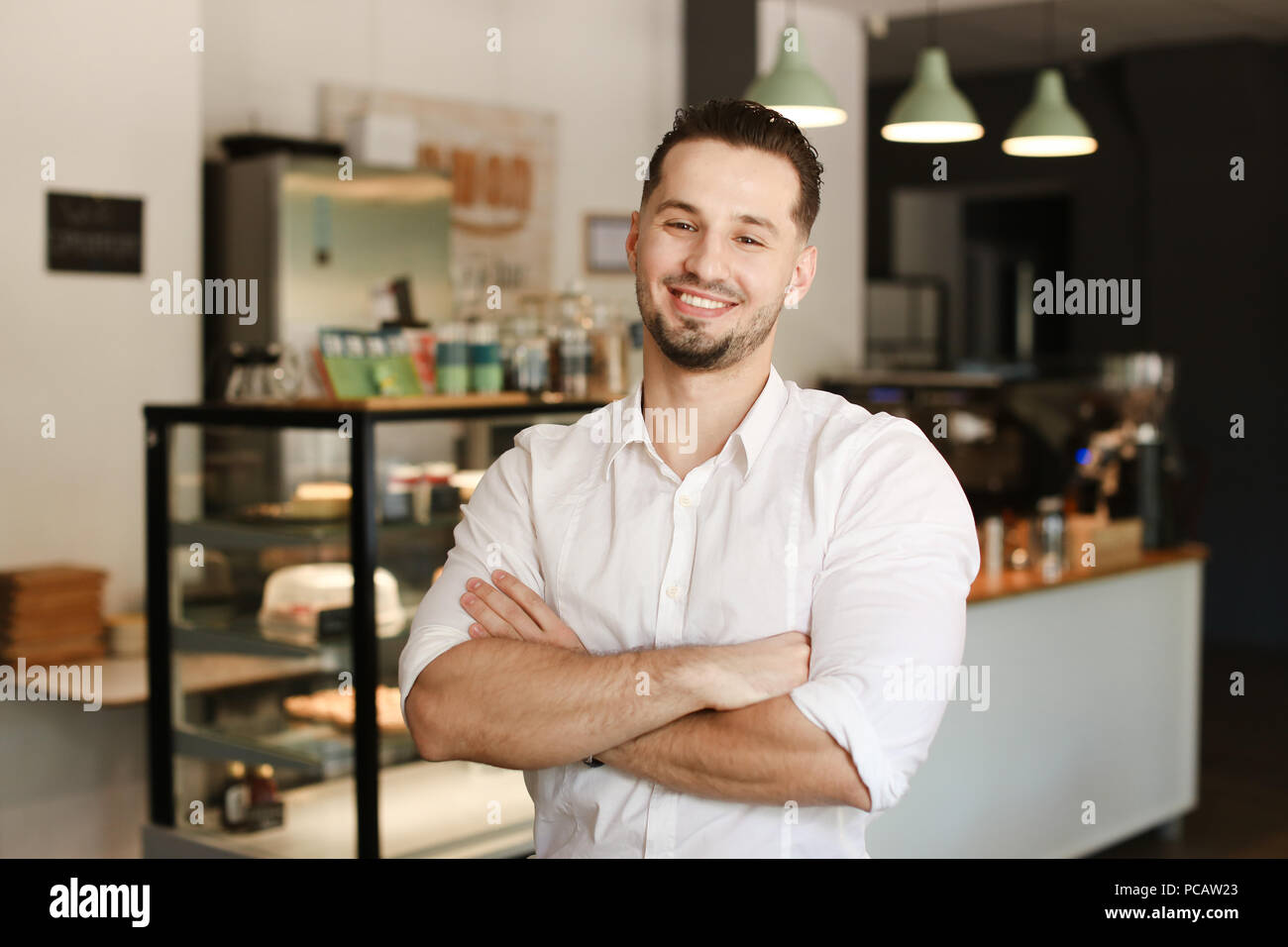 Young administrator standing with at cafe and wearing white shirt. Stock Photo
