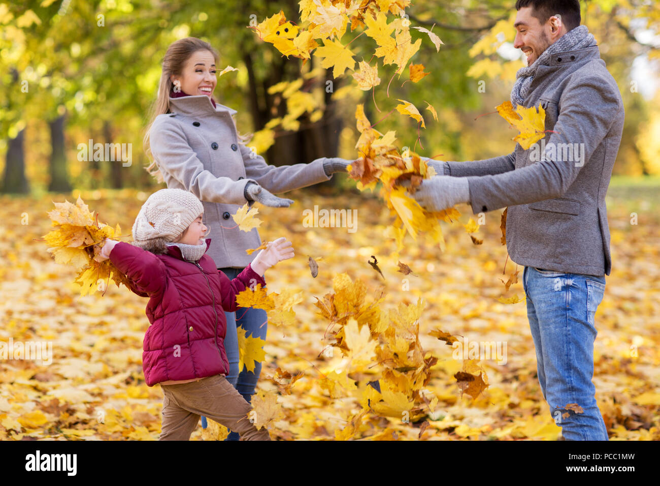 happy family playing with autumn leaves at park Stock Photo - Alamy