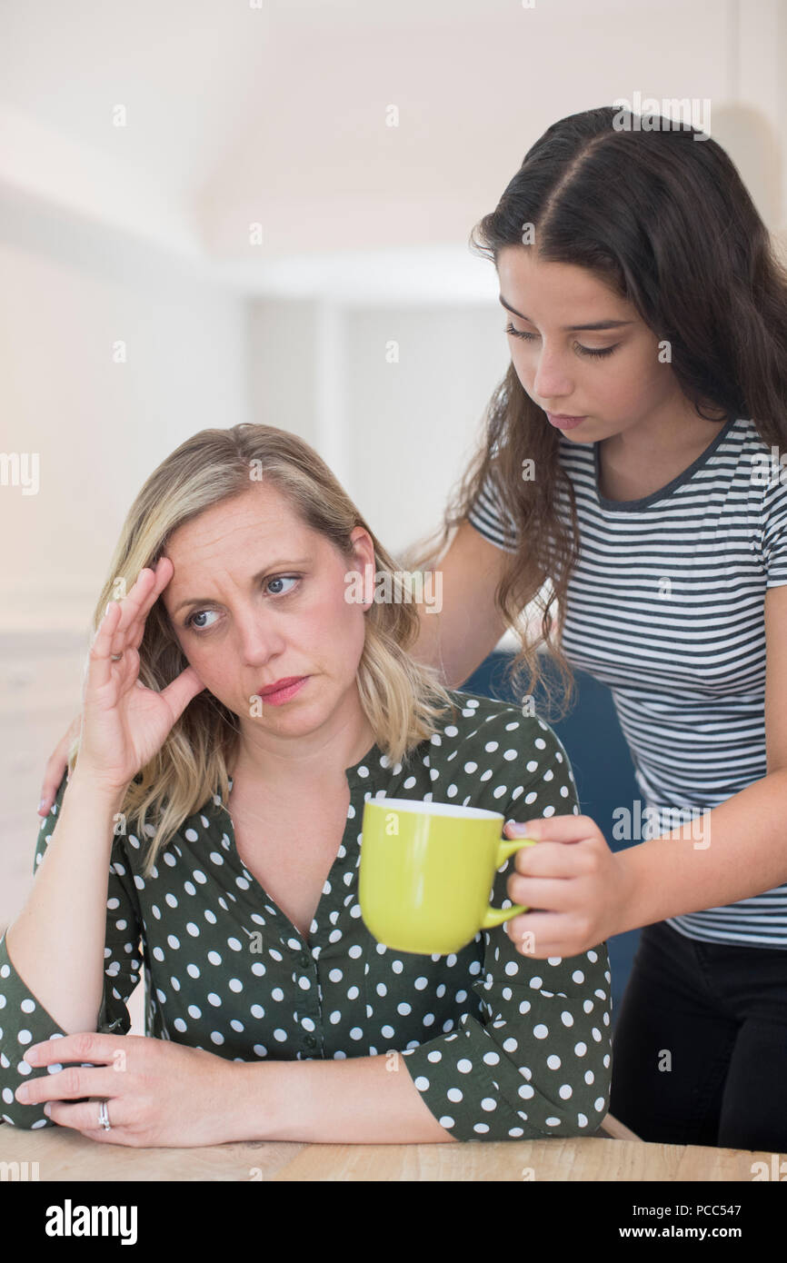 Teenage Daughter Making Drink For Parent Suffering With Mental Health Problems Stock Photo