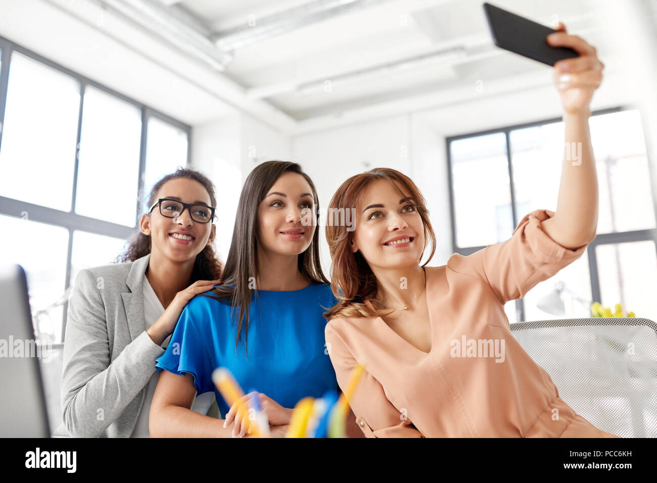 happy businesswomen taking selfie at office Stock Photo - Alamy