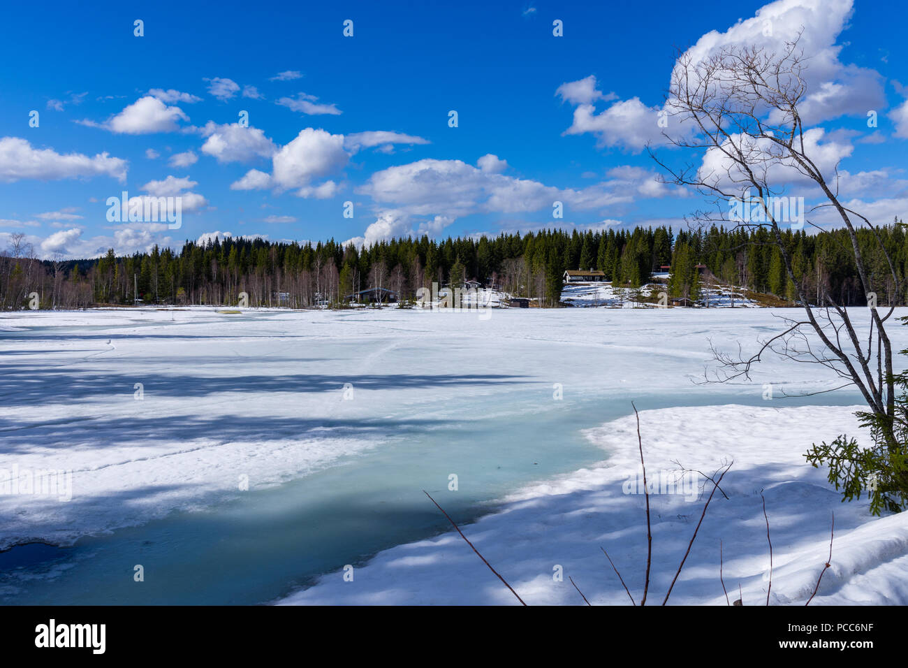 Small houses in the snowy forest overlooking the frozen lake. Norway ...