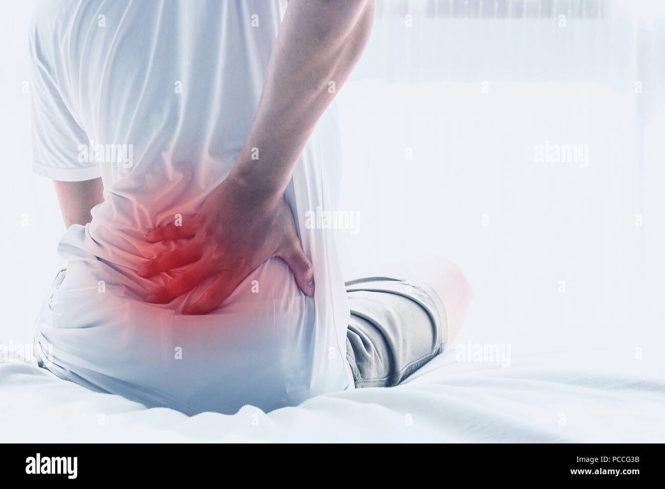 Asian man back pain and sit on bed in bedroom in the morning.color tone