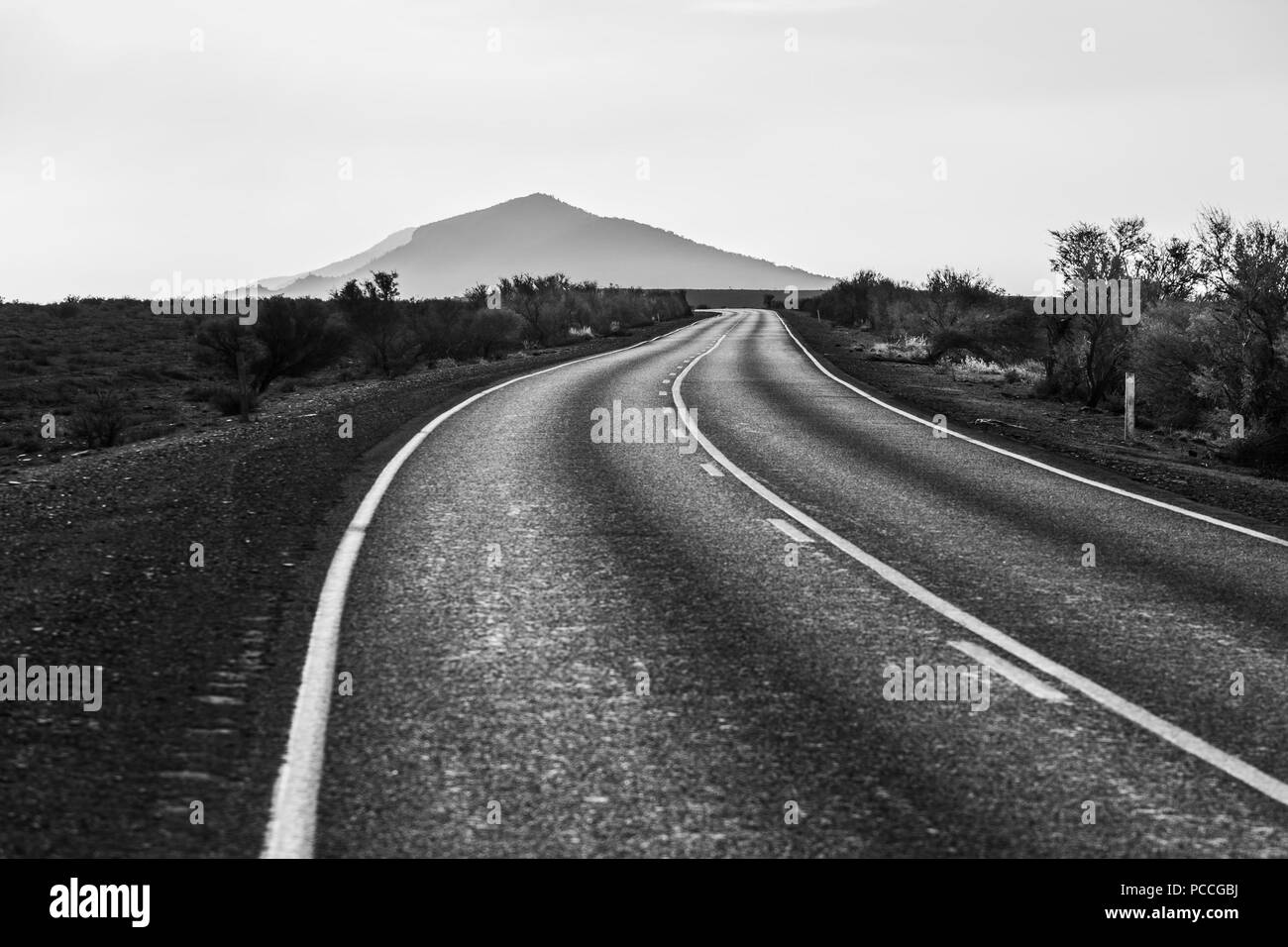 Winding road leading to a scenic mountain peak in black and white Stock ...