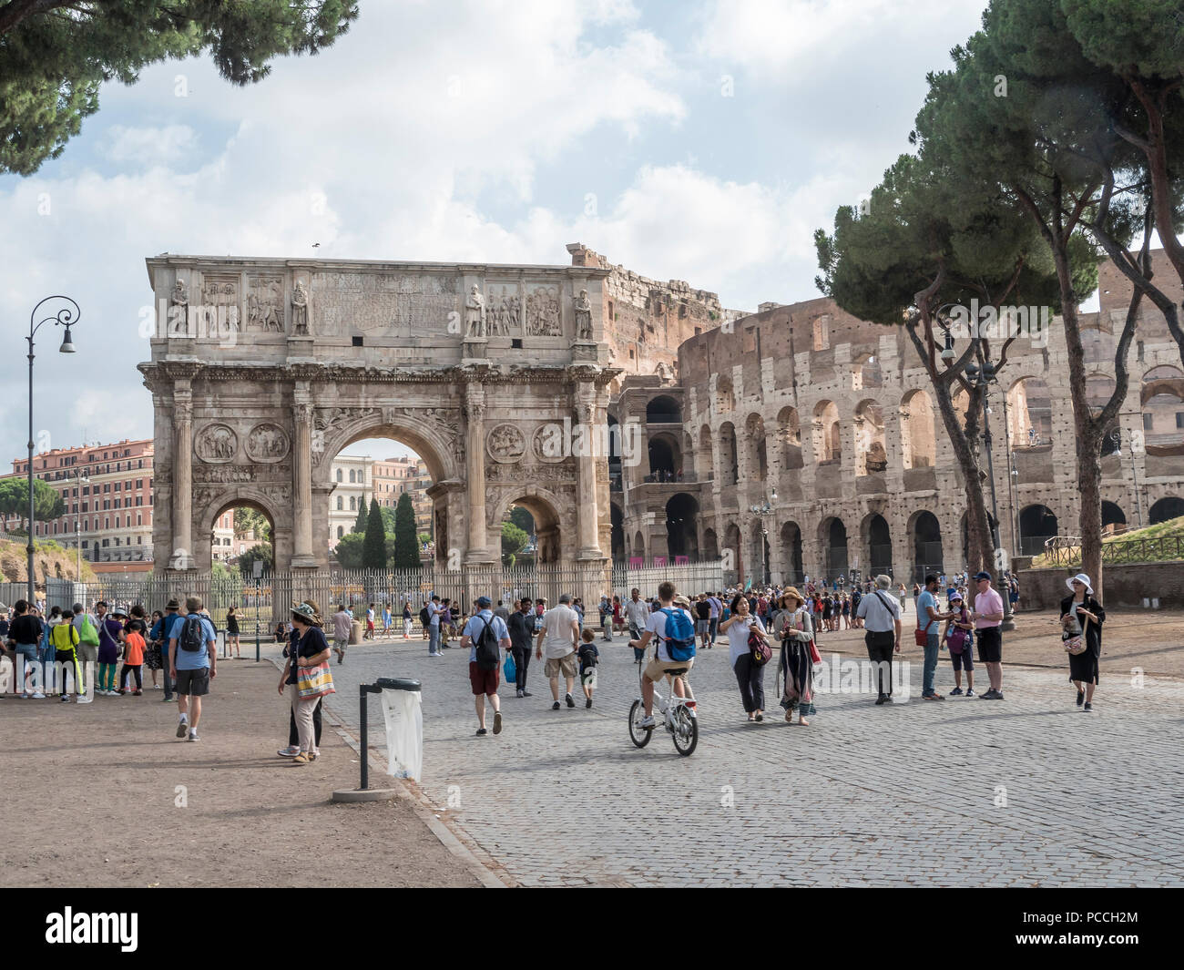 People walking around the walls and arched gate of the Colosseum, Rome, Italy Stock Photo