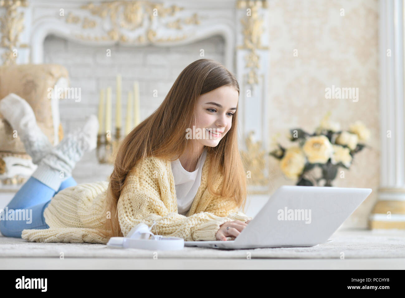 Beautiful teen girl lying on floor and using laptop Stock Photo - Alamy