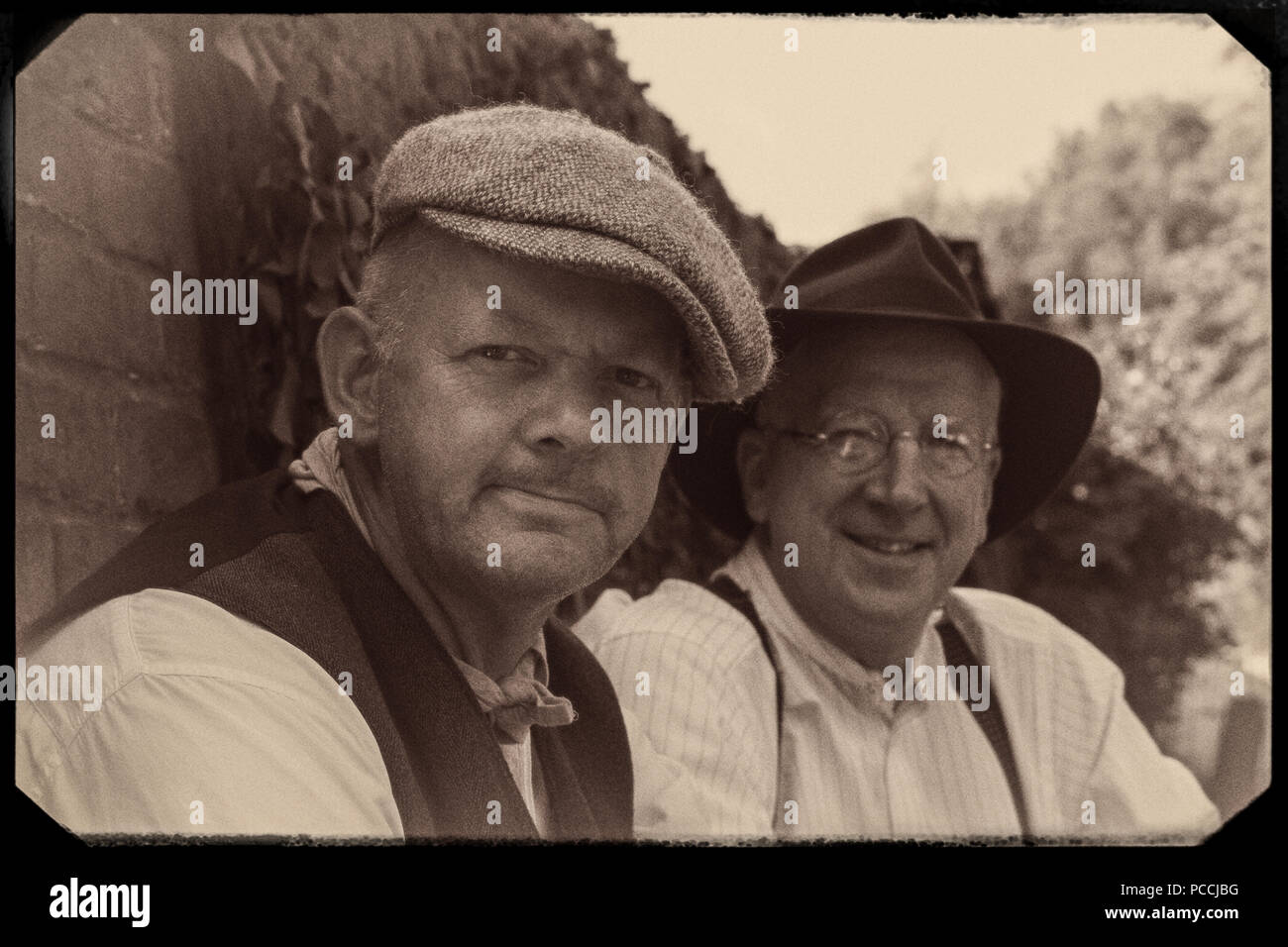 Monochrome, old-style photograph of male re-enactors, Black Country Living Museum UK, 1940's wartime event. 1940s men, vintage workers, wearing hats. Stock Photo