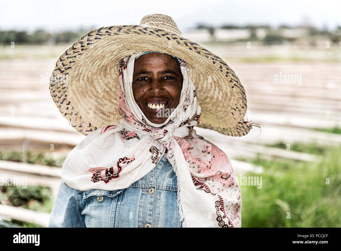 Addis Ababa / Ethiopia - June 30 2017 : Potrait of Ethiopian Women Smiling strawberry farm in background Stock Photo