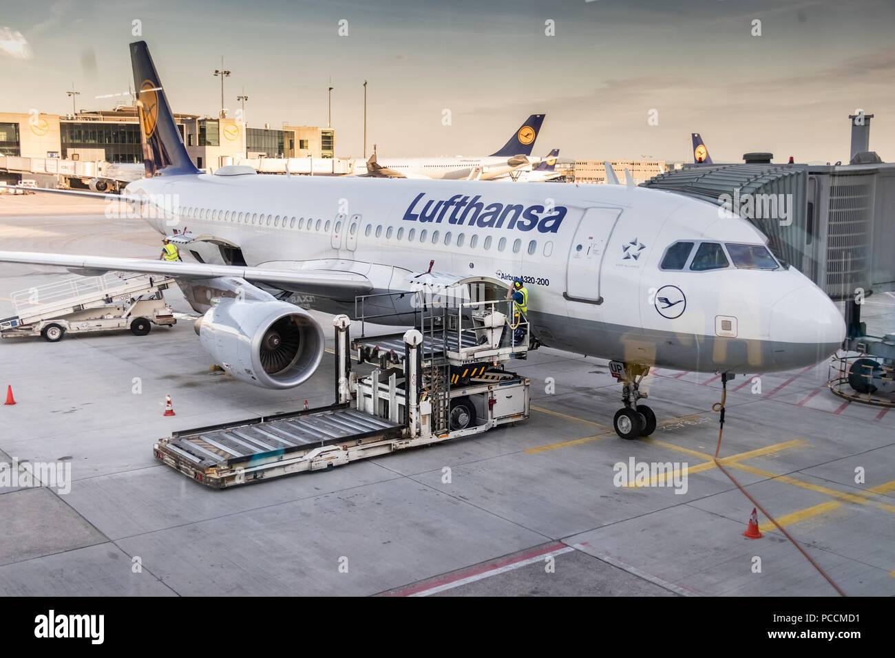 Frankfurt, Germany - July 3th, 2018: Aircraft truck bags loader at the cargo door of a Lufthansa Airbus A320 at Frankfurt main airport. Stock Photo