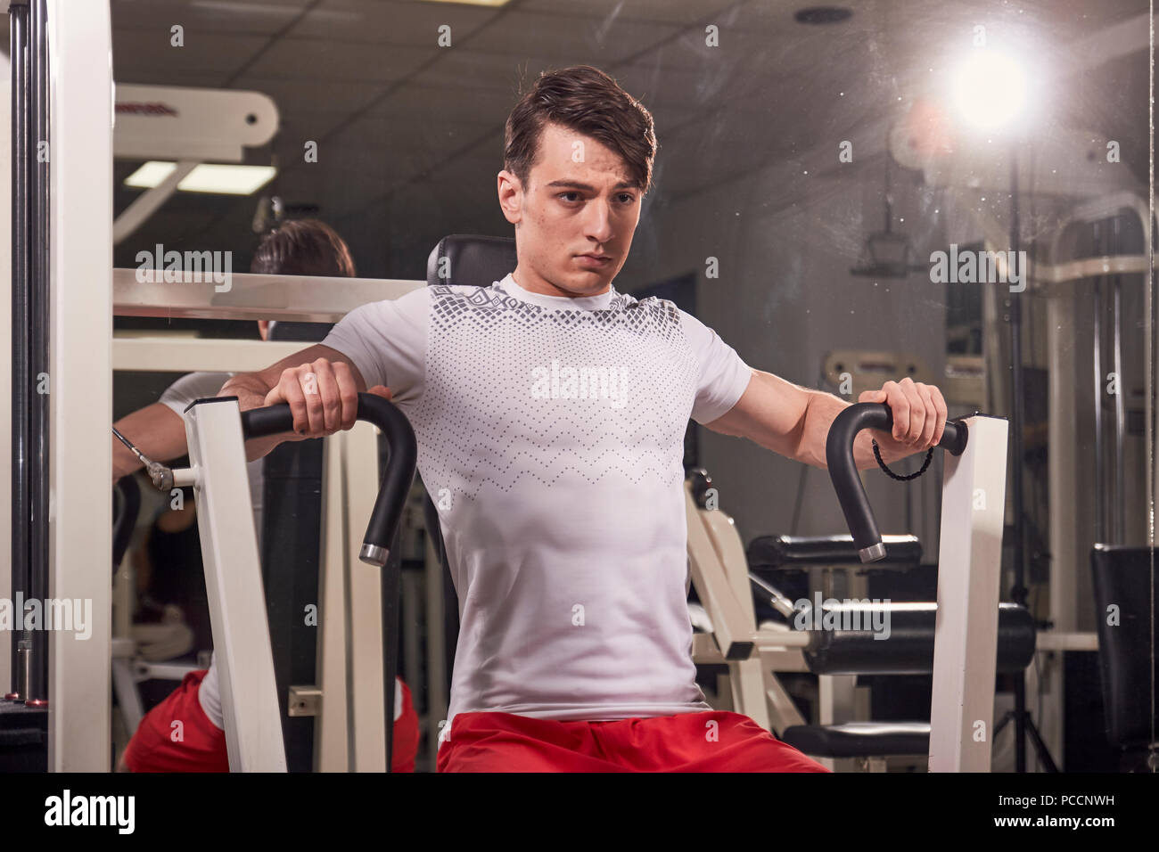 Premium Photo  Young determined fitness woman doing exercises at chest  press machine at modern gym