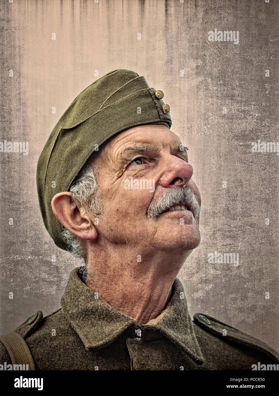 Close portrait of senior male with grey moustache (like Dad's Army character) in military, army uniform at UK 1940s event. Stock Photo