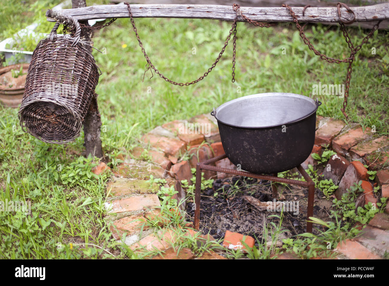 Wooden Basket And A Cast Iron Cauldron Over A Fire Pit Made From
