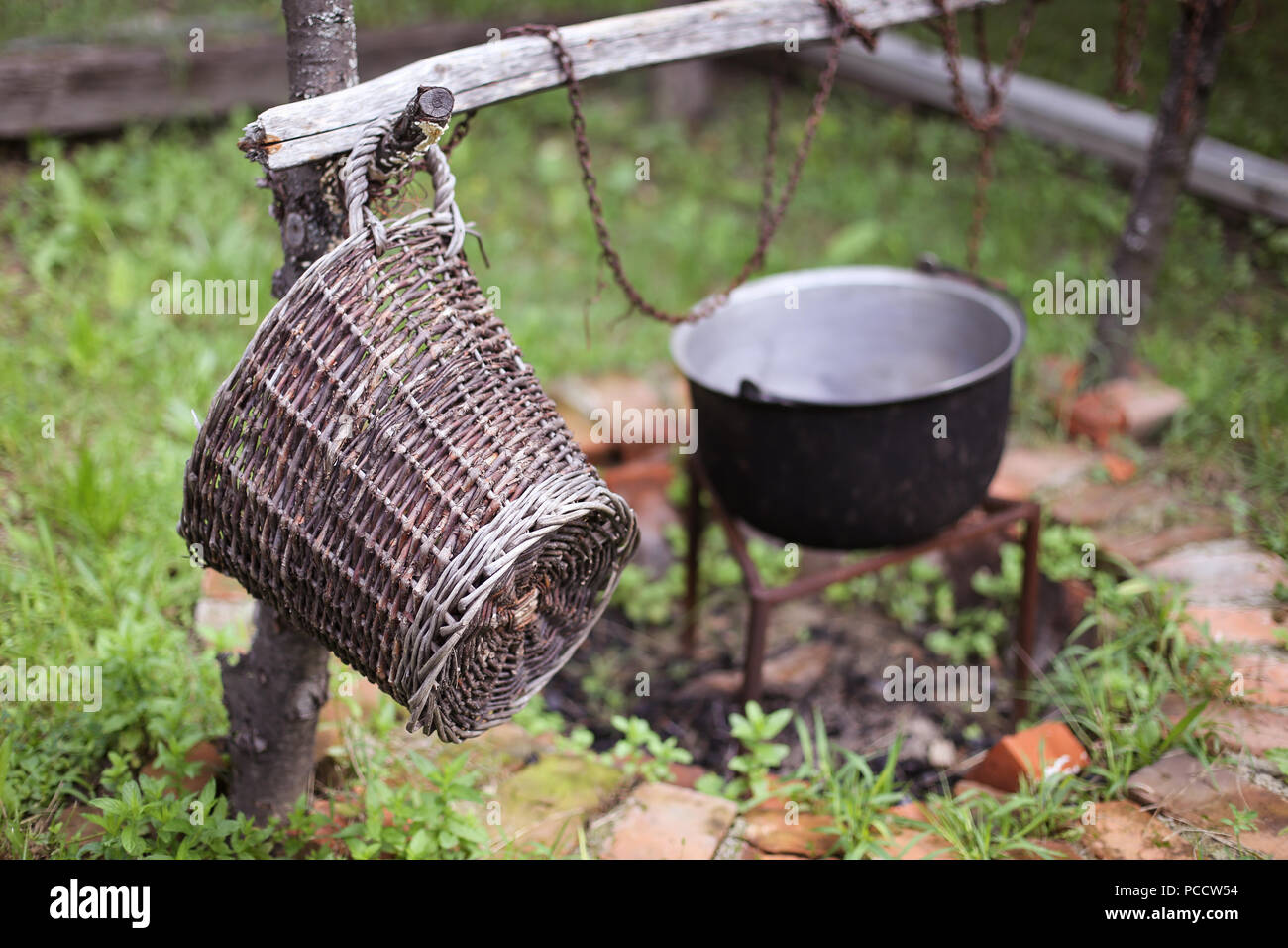 Wooden Basket And A Cast Iron Cauldron Over A Fire Pit Made From