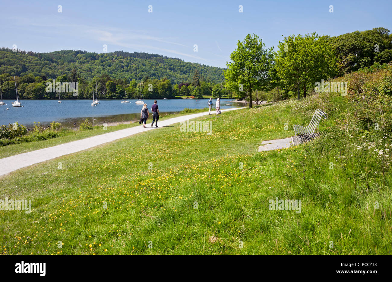 People walking by the lake lakeshore in summer Cockshott Point Bowness on Windermere Cumbria