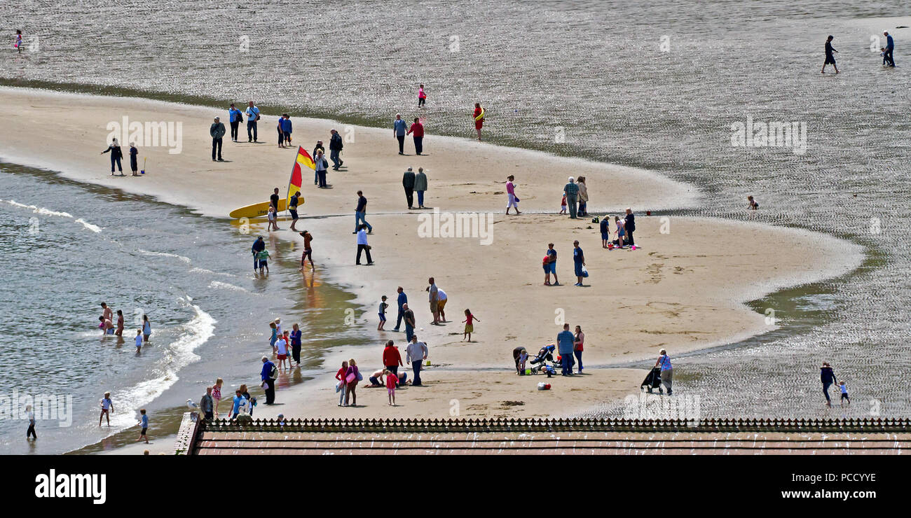 Different people doing different things - a Lowry-like scene on the sands of Scarborough’s South Bay beach. Stock Photo