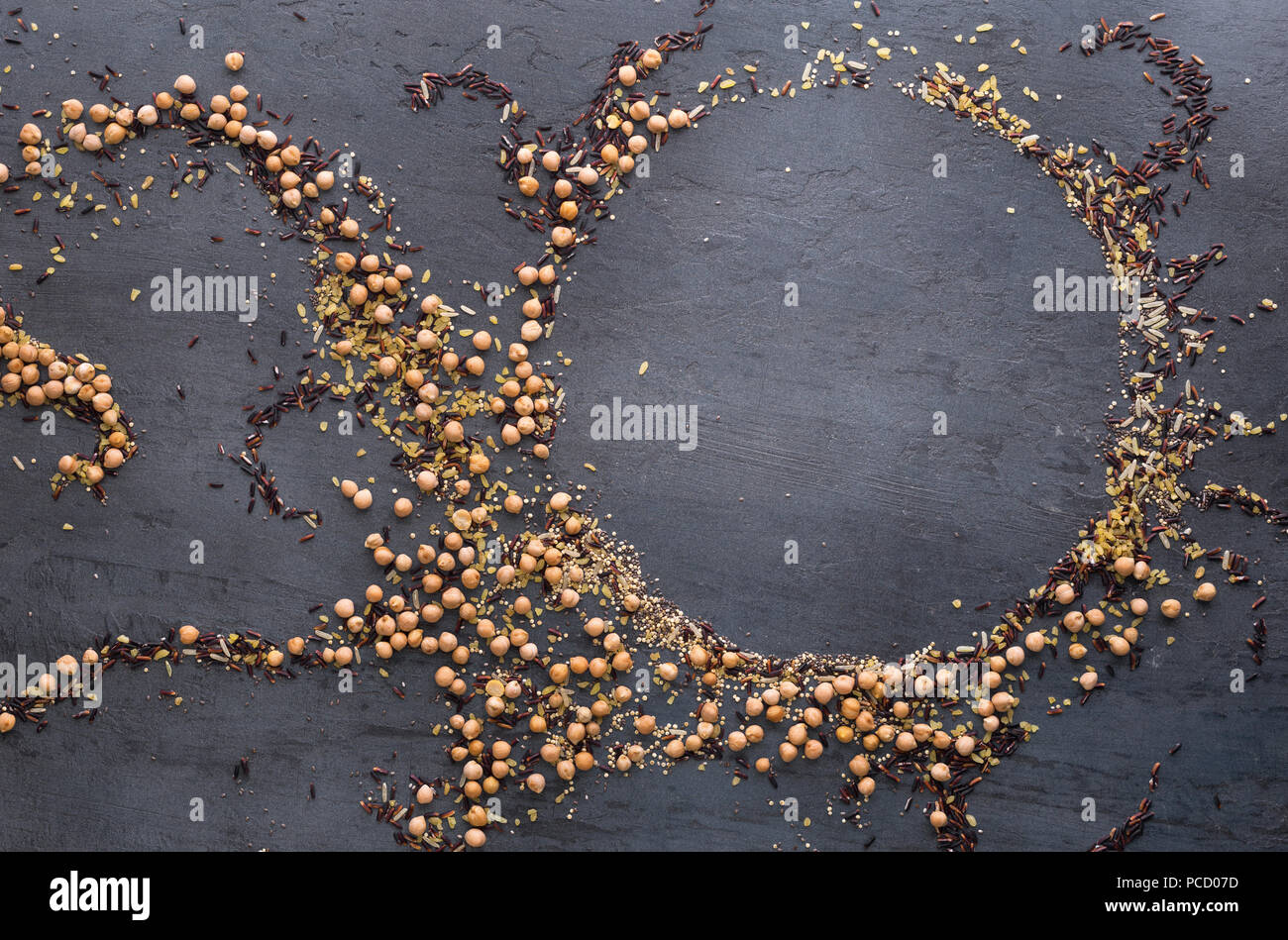 Pattern of different seeds for a healthy food on dark background. Seeds of quinoa, chia, bulgur, chickpeas, black rice and brown rice Stock Photo