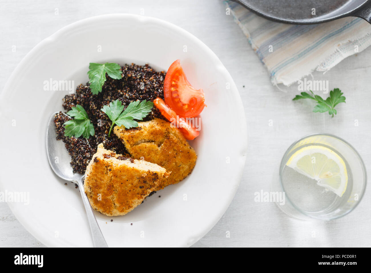 Top View Healthy Vegetarian Food. Plate with black quinoa and oatmeal cutlets with prunes on white wooden table with lemon water. Copy space Stock Photo