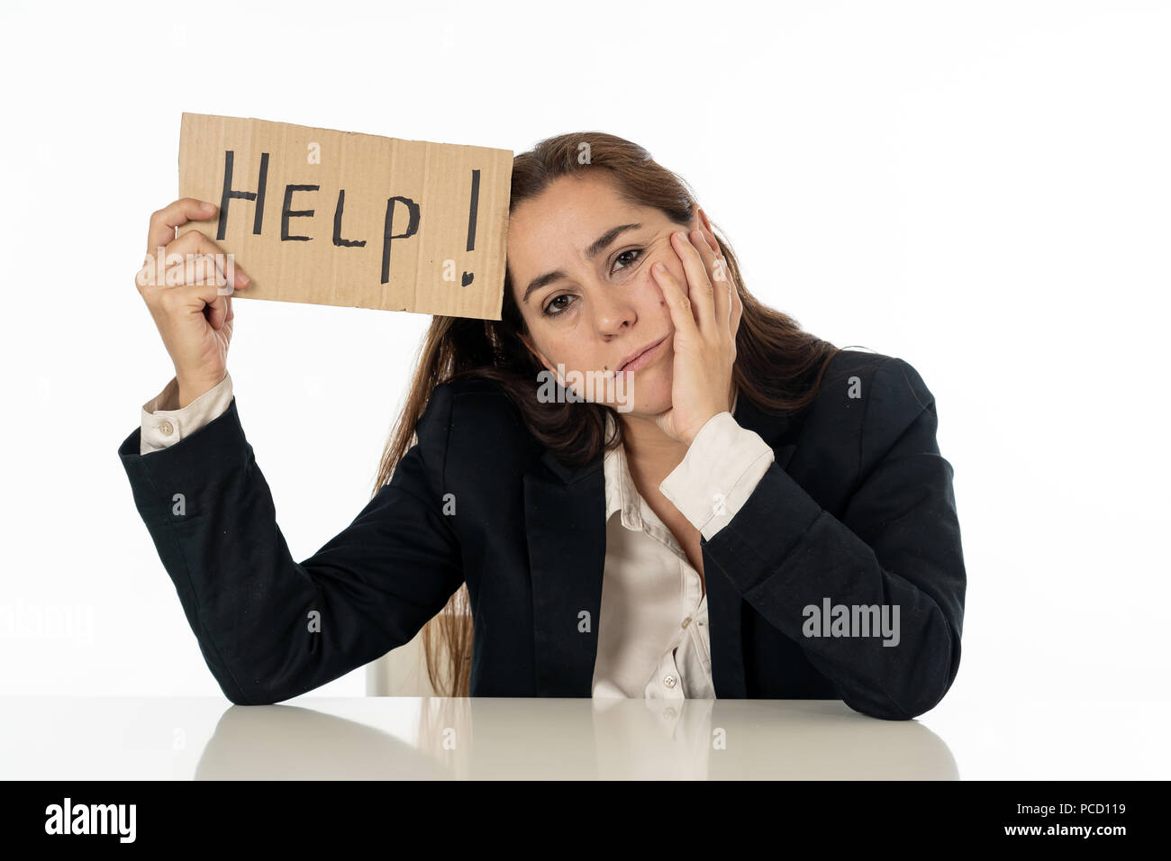 Young attractive frustrated and tired latin businesswoman holding help sign message exhausted, sad under pressure and stress isolated on white in unem Stock Photo