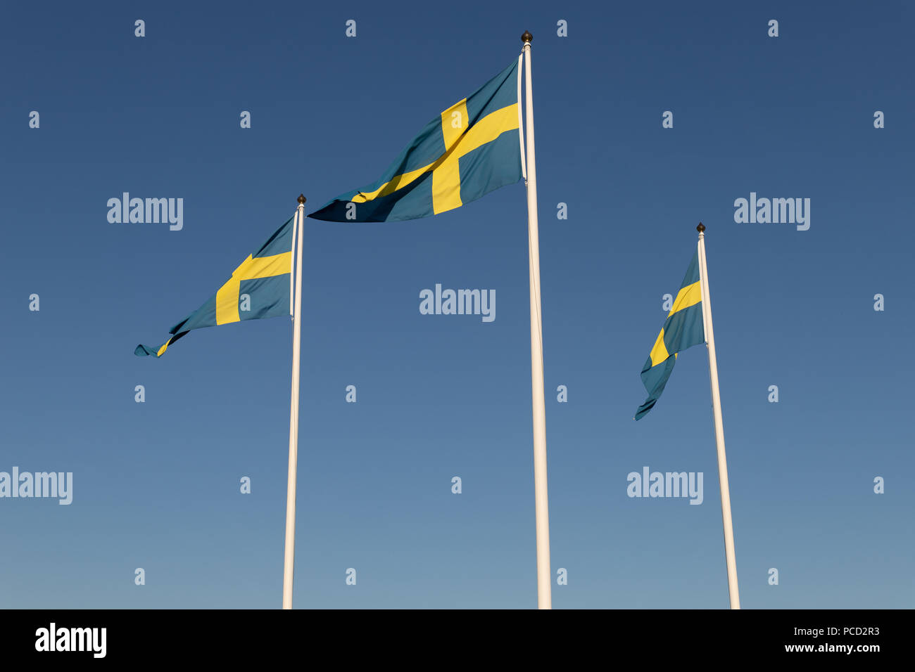 Thre flags from Sweden waving in the air Stock Photo