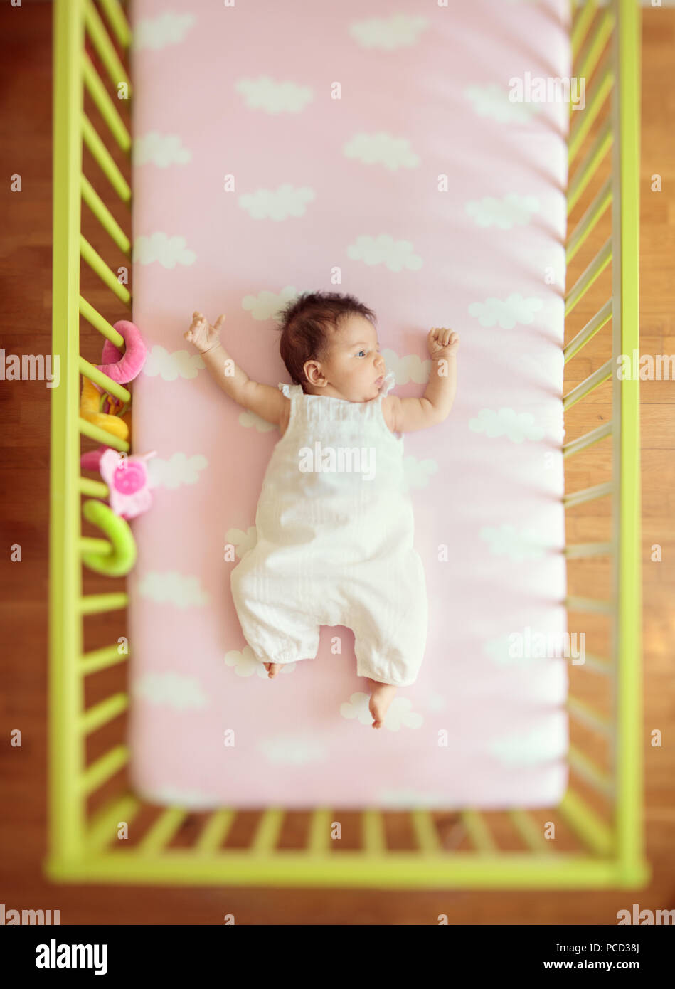 Adorable baby girl lying in a cot bed Stock Photo Alamy