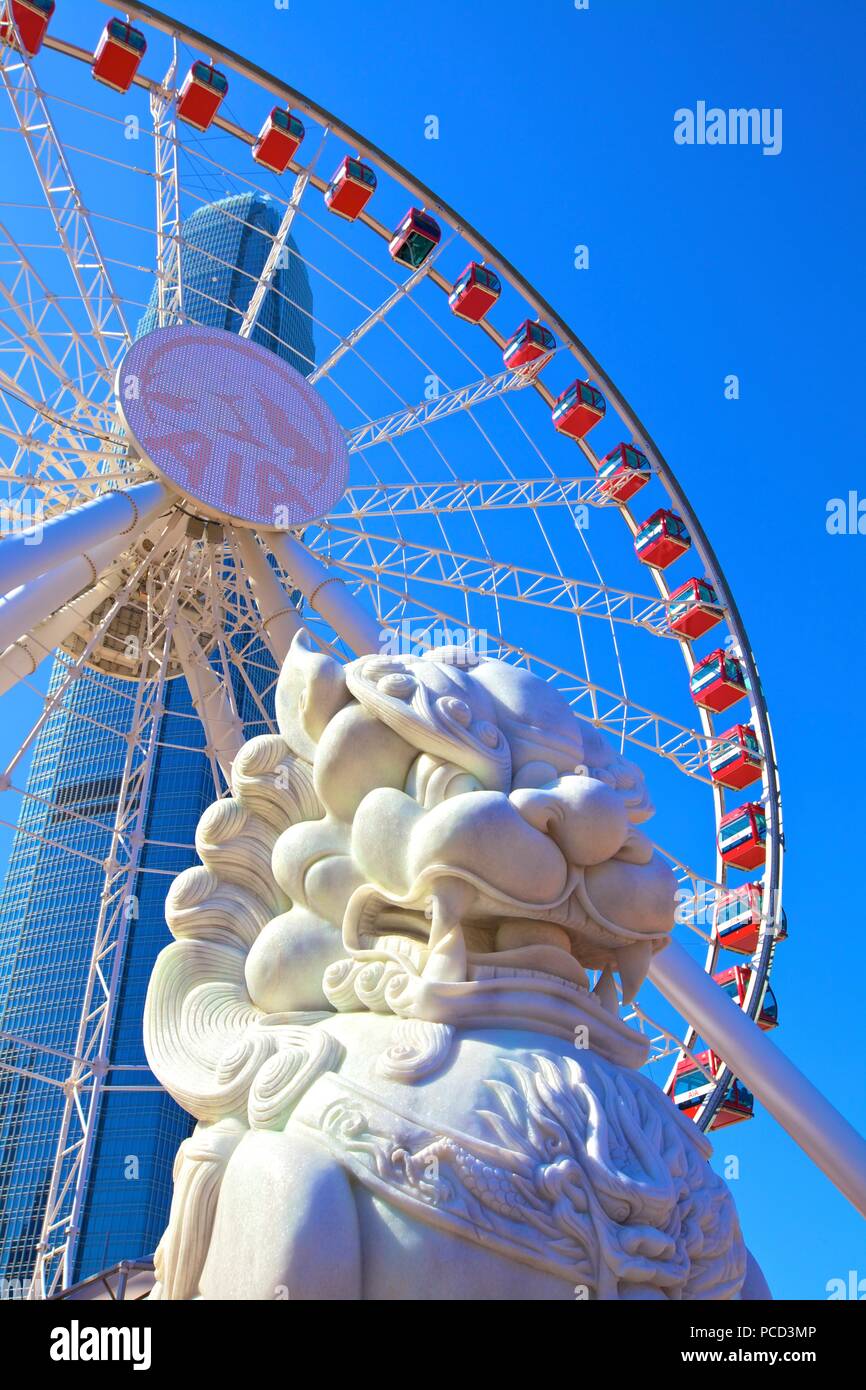 Chinese Guardian Lion with The Hong Kong Observation Wheel and IFC Building, Hong Kong, China, Asia Stock Photo