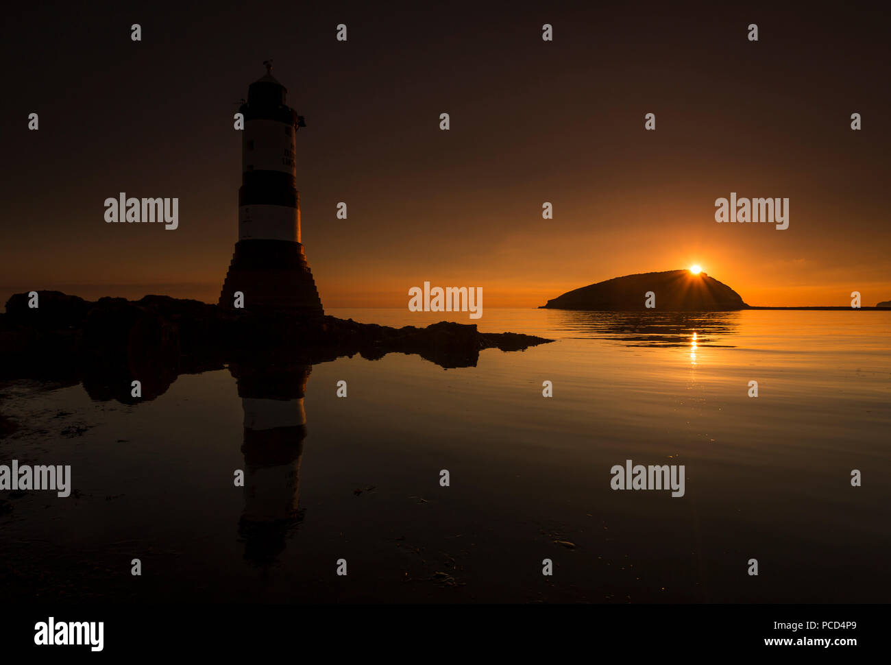 Lighthouse at Penmon Point, Anglesey, North Wales with Puffin Island in the background at sunrise Stock Photo