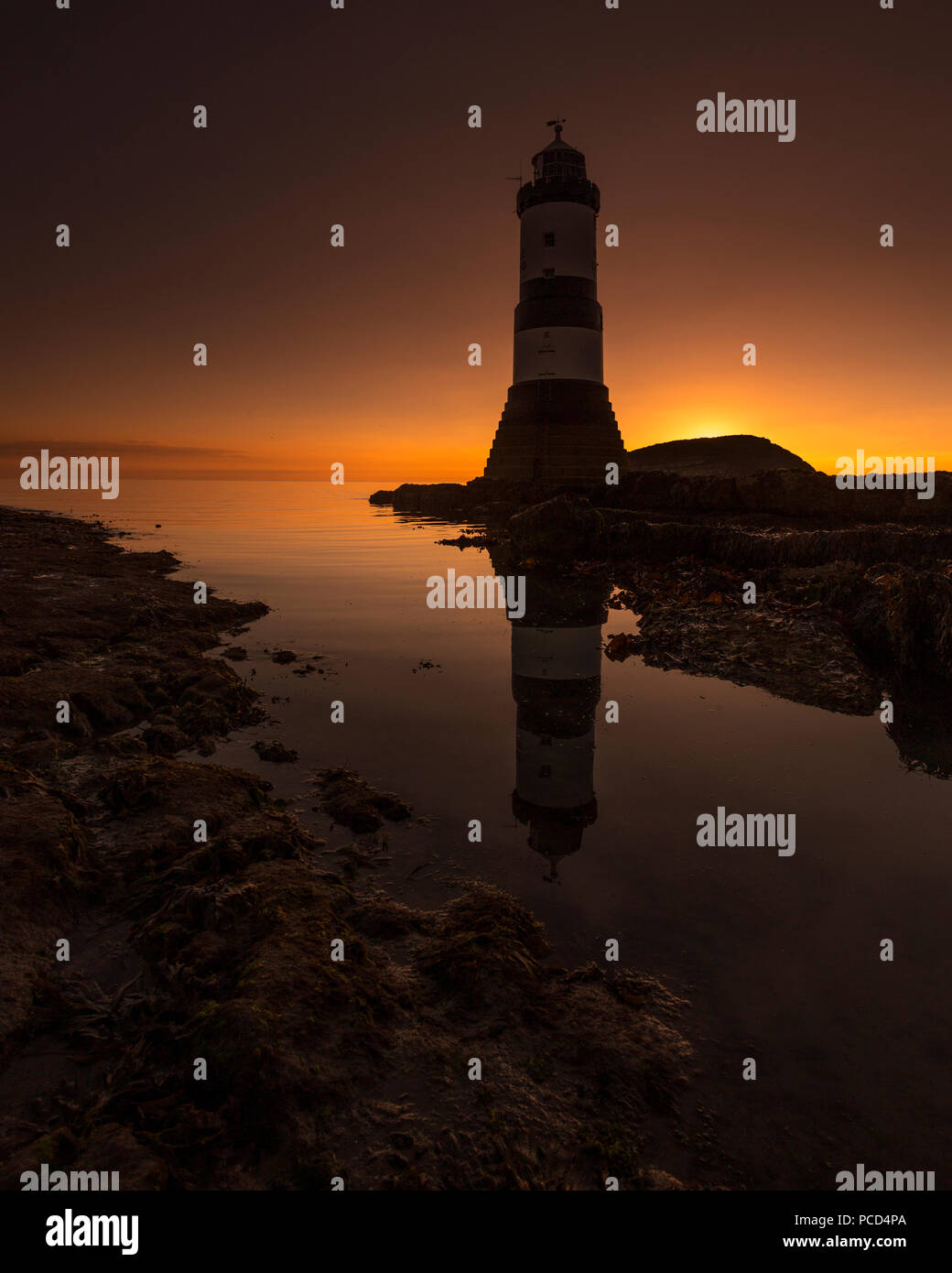 Lighthouse at Penmon Point, Anglesey, North Wales with Puffin Island in the background at sunrise Stock Photo