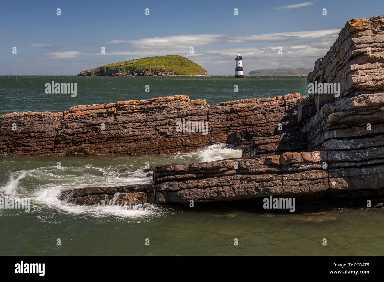 Lighthouse at Penmon Point, Anglesey, North Wales with Puffin Island in the background Stock Photo
