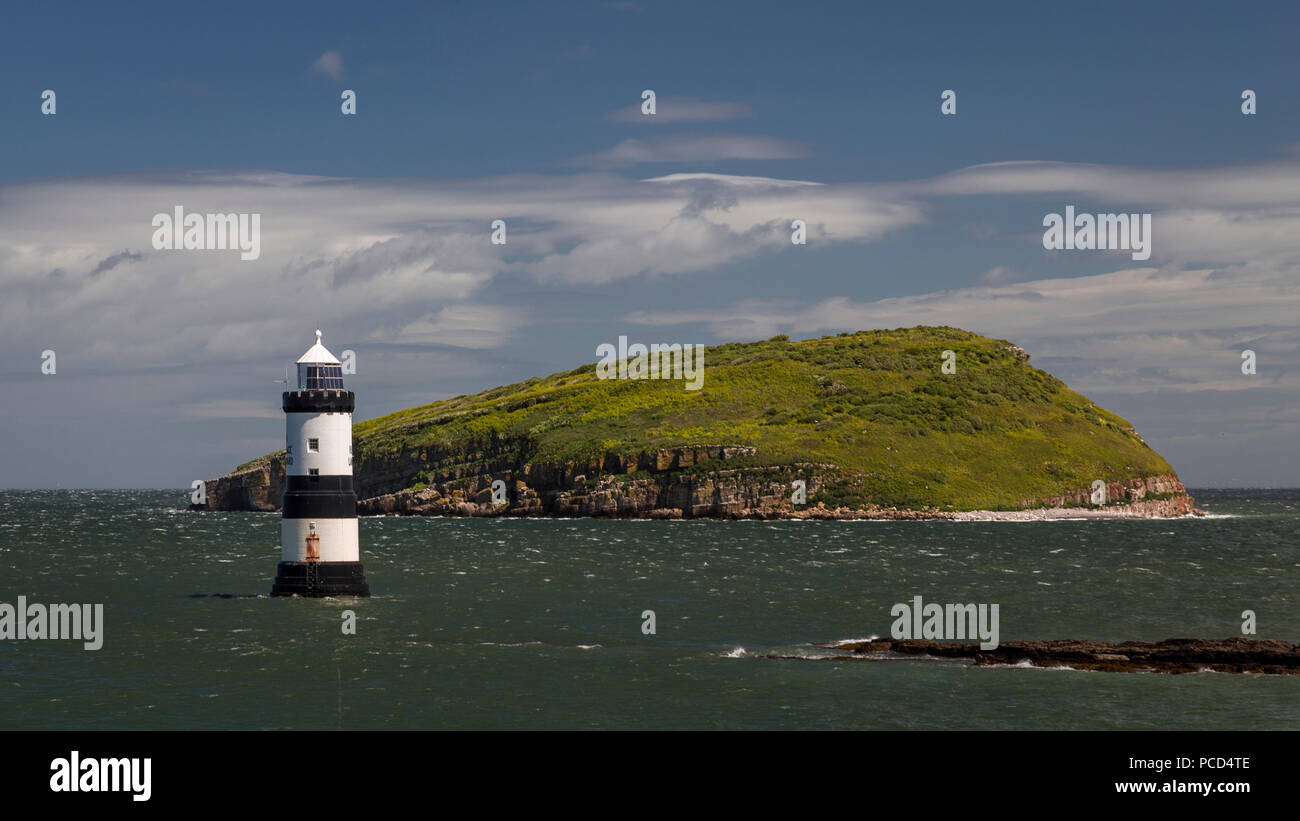 Lighthouse at Penmon Point, Anglesey, North Wales with Puffin Island in the background Stock Photo