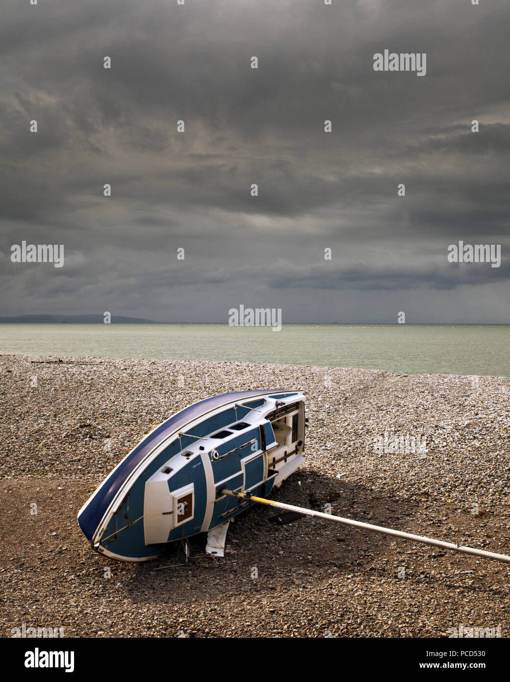 Wrecked yacht on the shingle beach at Penmon Point, Anglesey, North Wales Stock Photo