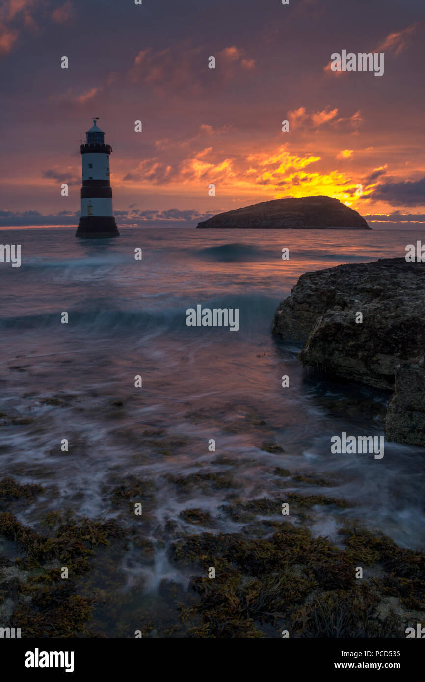 Lighthouse at Penmon Point at sunrise, Anglesey, North Wales, with Puffin Island in the background Stock Photo