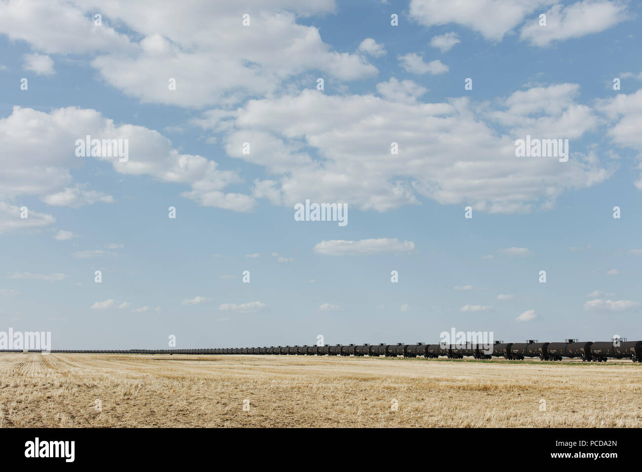 Oil train cars and fallow farmland, near Swift Current, Saskatchewan, Canada. Stock Photo